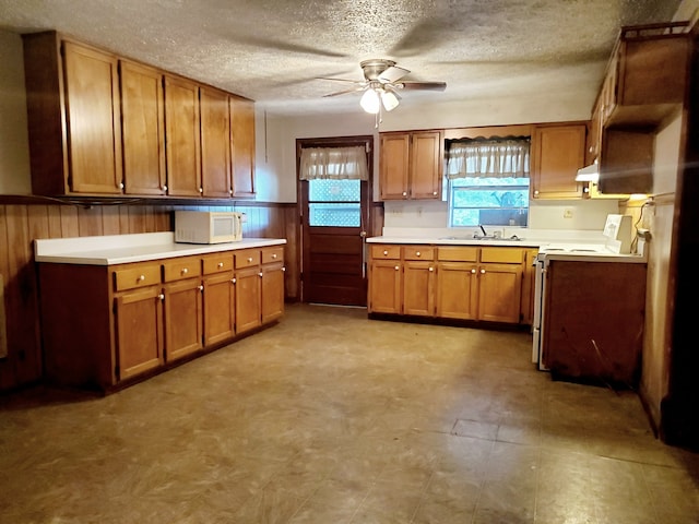 kitchen featuring range, light tile patterned floors, a textured ceiling, ceiling fan, and sink