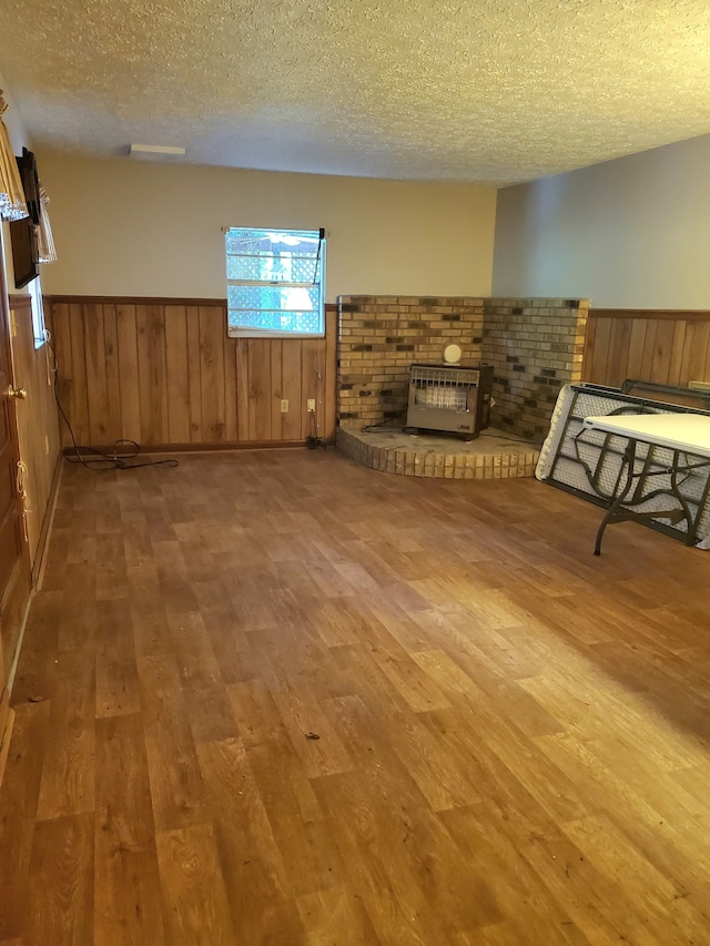 unfurnished living room featuring a fireplace, wood-type flooring, and a textured ceiling