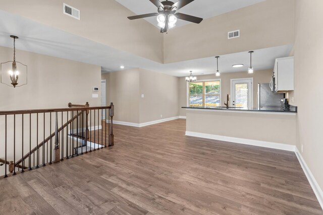 unfurnished room featuring ceiling fan with notable chandelier, dark hardwood / wood-style flooring, and sink