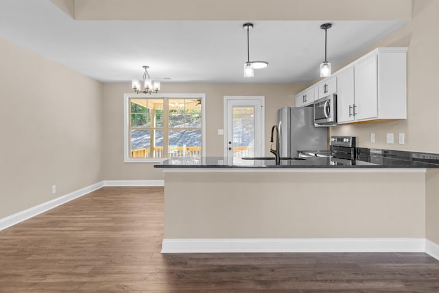 kitchen with a notable chandelier, dark hardwood / wood-style floors, decorative light fixtures, and appliances with stainless steel finishes