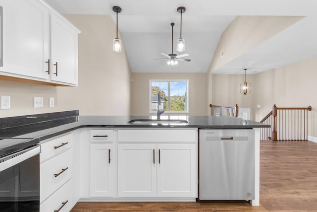 kitchen featuring white cabinets, sink, appliances with stainless steel finishes, and vaulted ceiling