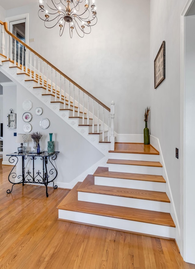 stairway featuring hardwood / wood-style floors and a notable chandelier