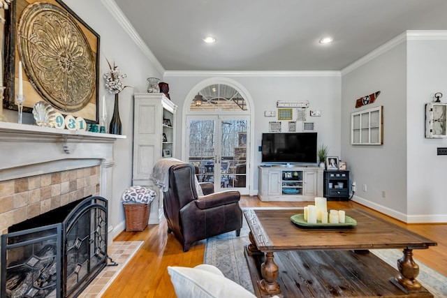 living room with crown molding, hardwood / wood-style floors, french doors, and a brick fireplace