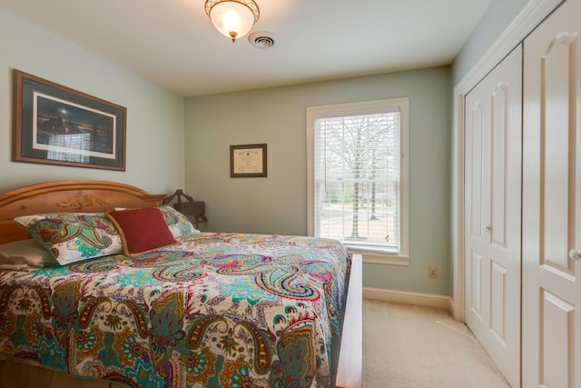 carpeted bedroom featuring multiple windows and a closet