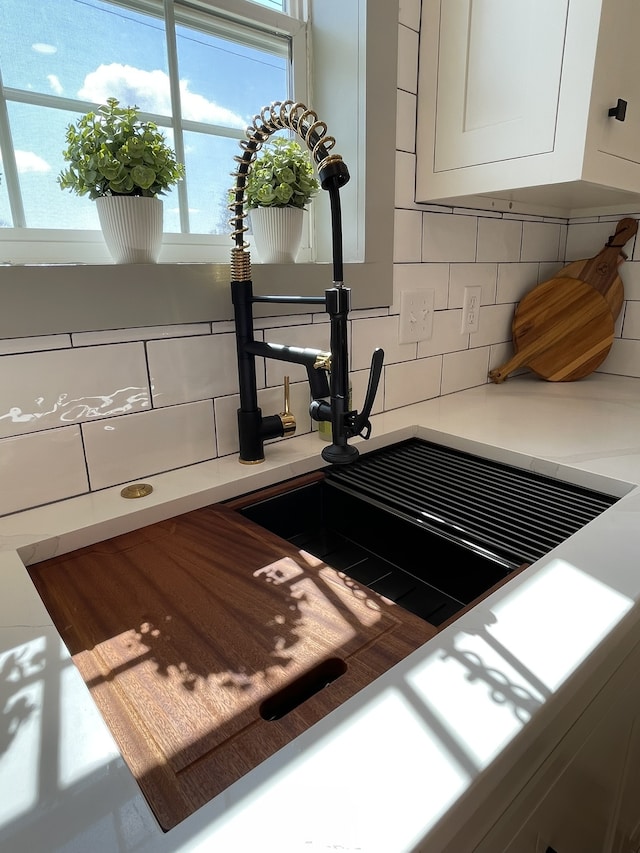 interior details featuring tasteful backsplash and white cabinetry