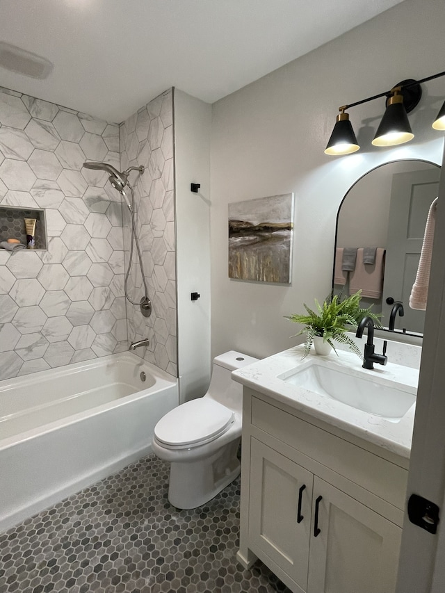 full bathroom featuring tiled shower / bath combo, vanity, and toilet