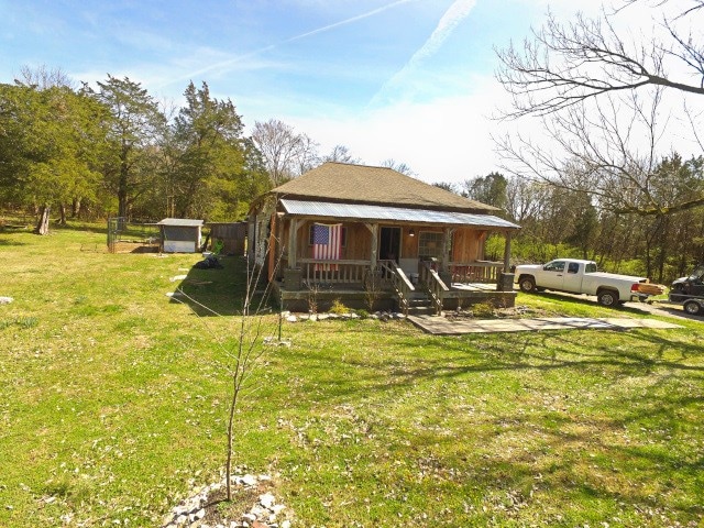 view of yard featuring an outdoor structure and covered porch