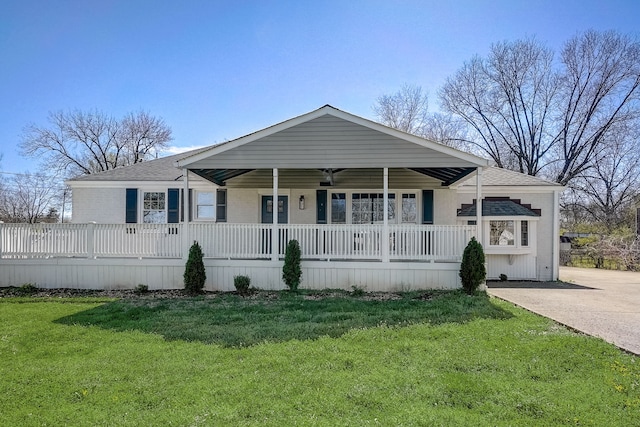 back of property featuring covered porch and a yard