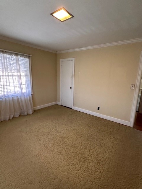 spare room with dark colored carpet and crown molding