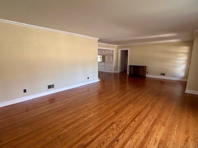 spare room featuring ornamental molding and hardwood / wood-style flooring