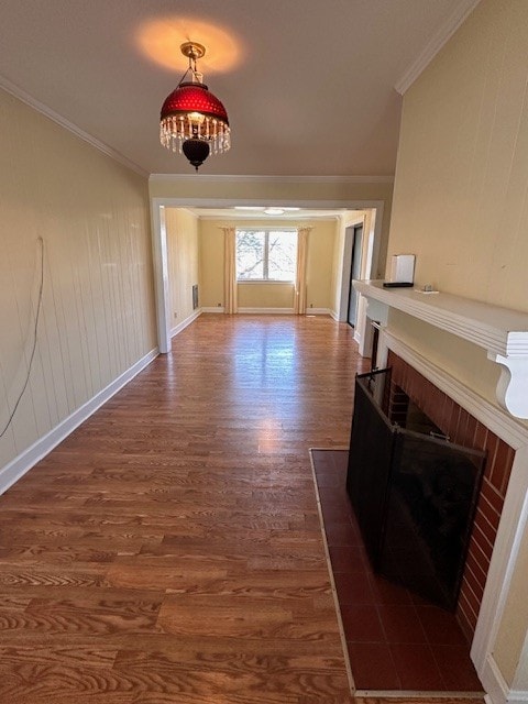 unfurnished living room featuring a brick fireplace, dark hardwood / wood-style floors, and crown molding