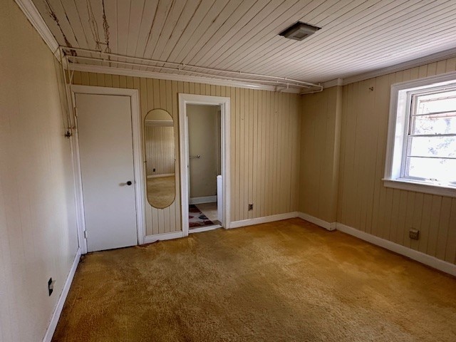 unfurnished room with crown molding, light carpet, and wood ceiling