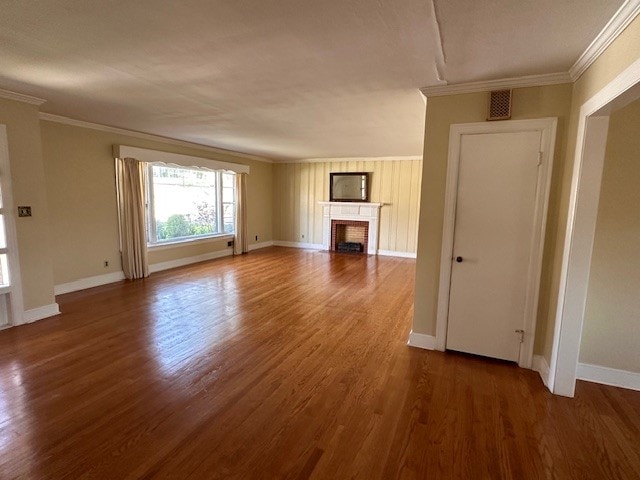 unfurnished living room featuring dark hardwood / wood-style flooring and ornamental molding