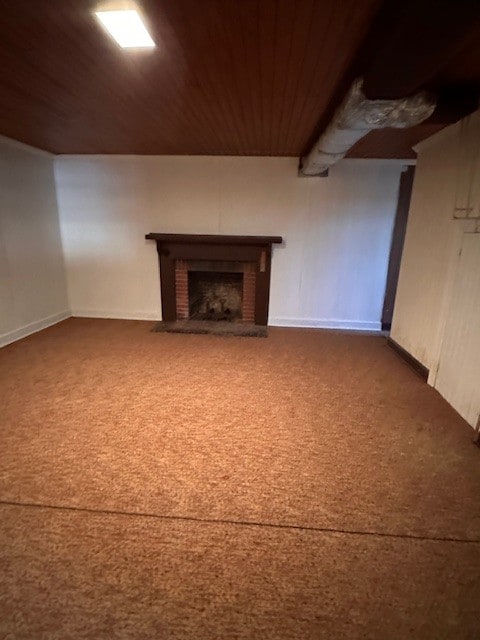 basement with wooden ceiling, a fireplace, and dark colored carpet