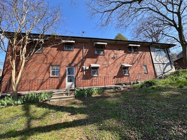 rear view of property featuring a lawn