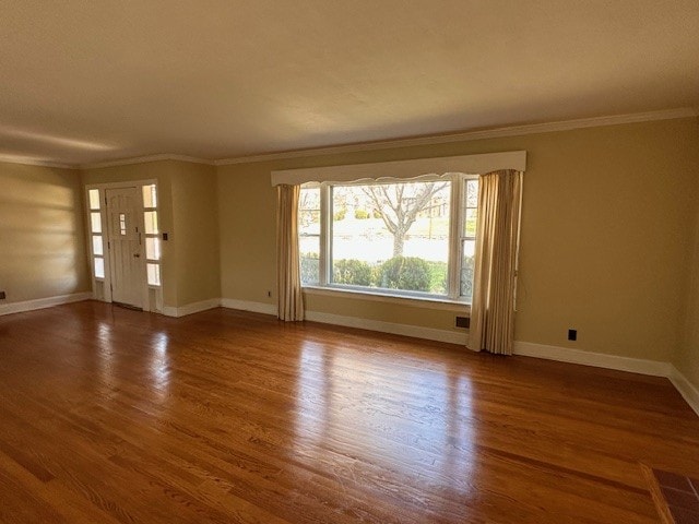 unfurnished room featuring hardwood / wood-style floors and ornamental molding