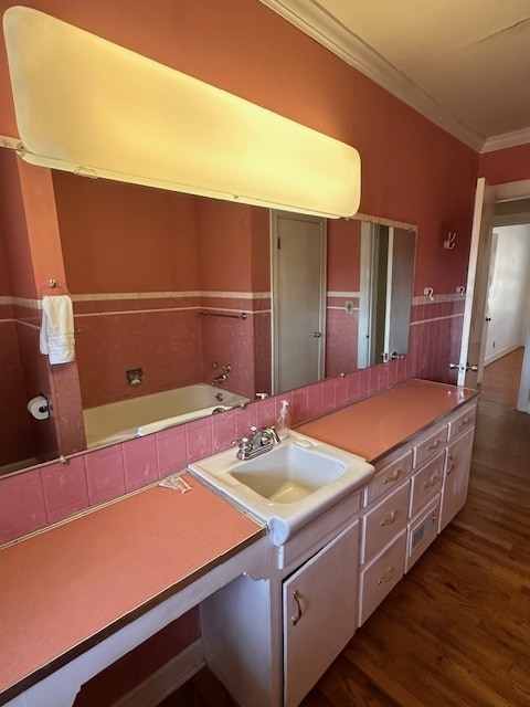 kitchen with dark hardwood / wood-style flooring, ornamental molding, and sink