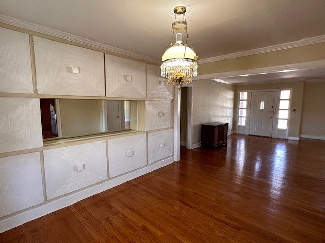 unfurnished living room featuring ornamental molding, dark wood-type flooring, and a chandelier