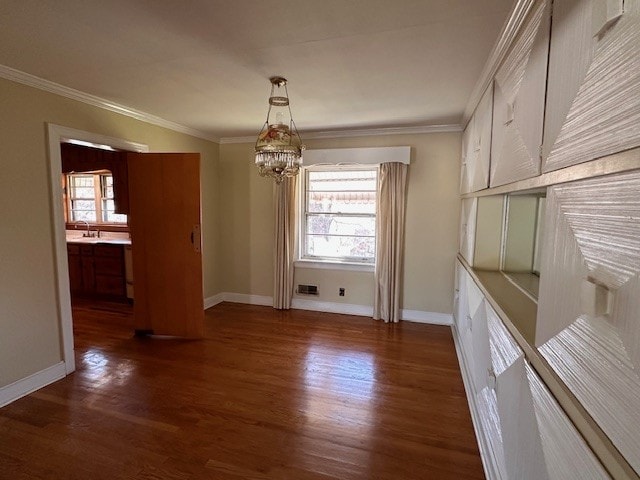 unfurnished dining area featuring ornamental molding, dark hardwood / wood-style floors, a chandelier, and sink