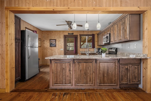 kitchen featuring stainless steel appliances, dark hardwood / wood-style flooring, kitchen peninsula, sink, and ceiling fan