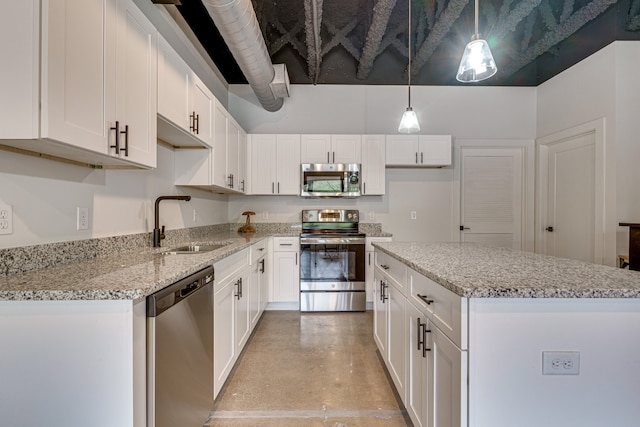 kitchen with appliances with stainless steel finishes, light stone counters, decorative light fixtures, sink, and white cabinets