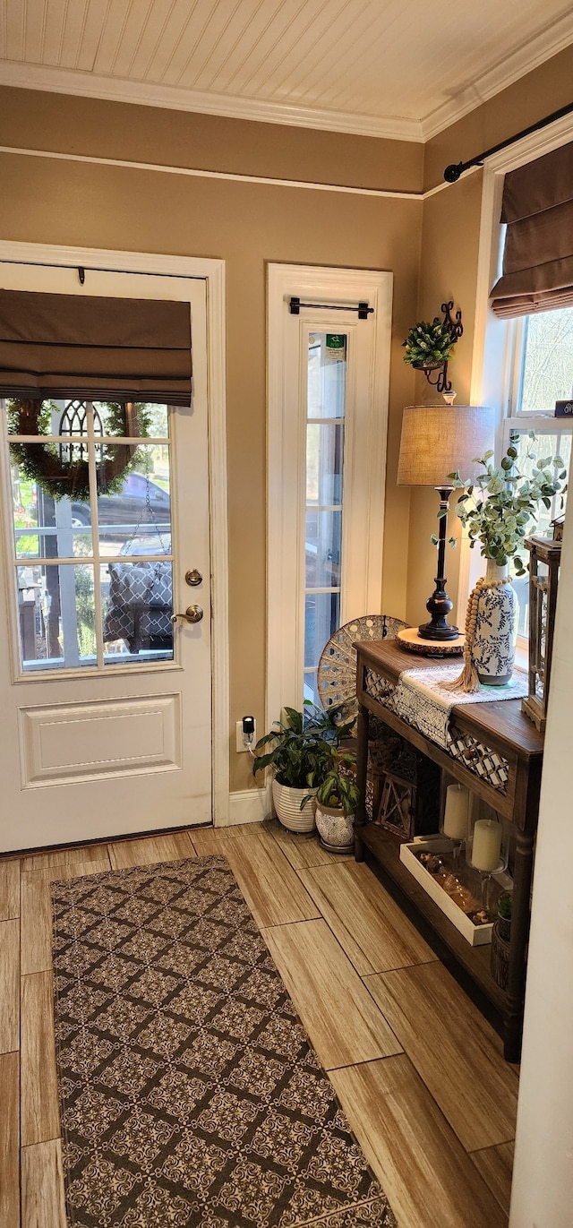 foyer featuring ornamental molding, a healthy amount of sunlight, and wood-type flooring