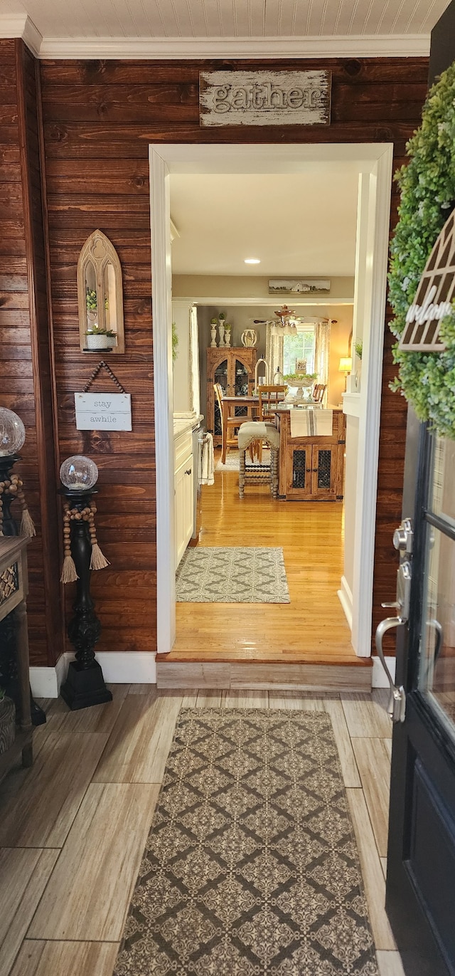 entryway with light hardwood / wood-style floors and wood walls