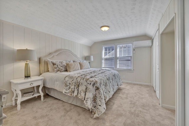 carpeted bedroom featuring a textured ceiling, vaulted ceiling, and a wall mounted AC