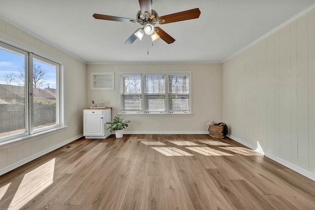 spare room featuring ceiling fan, crown molding, and light hardwood / wood-style flooring