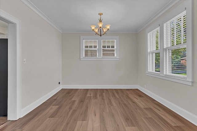 unfurnished dining area featuring hardwood / wood-style floors, crown molding, and a chandelier