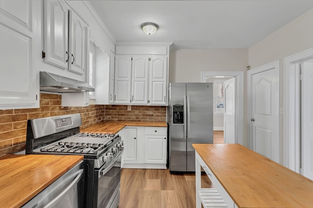 kitchen featuring decorative backsplash, white cabinetry, wooden counters, and appliances with stainless steel finishes