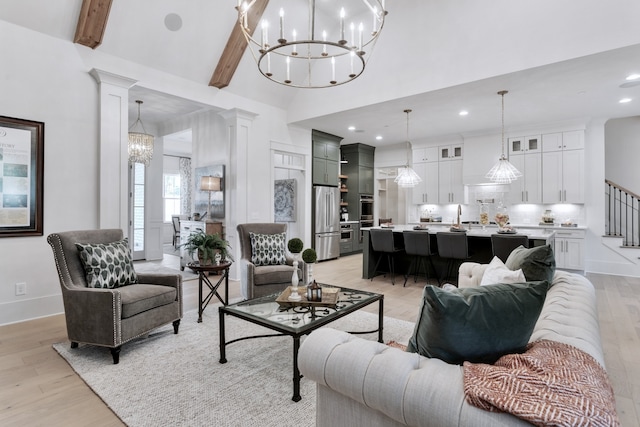 living room with lofted ceiling with beams, light wood-type flooring, ornate columns, and sink