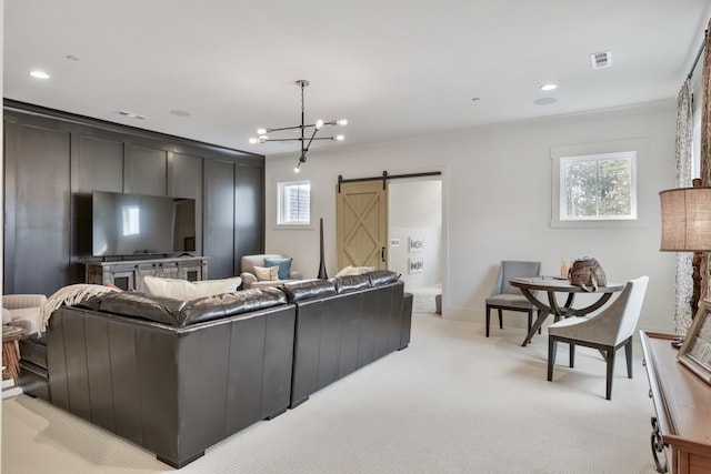 living room with light carpet, a barn door, an inviting chandelier, and crown molding