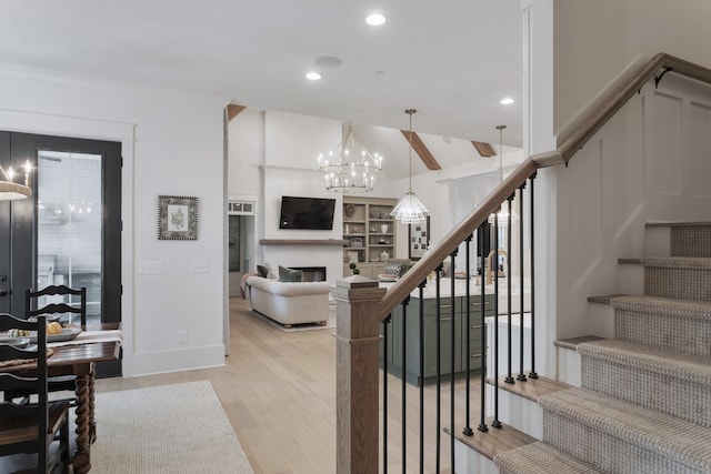 stairway with beam ceiling, an inviting chandelier, and hardwood / wood-style flooring