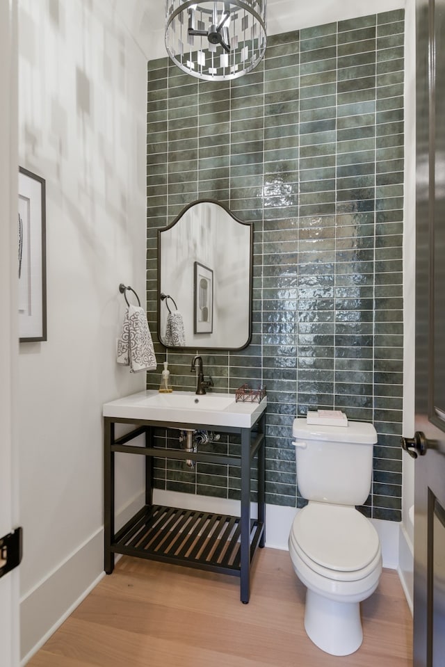 bathroom featuring toilet, wood-type flooring, and tile walls