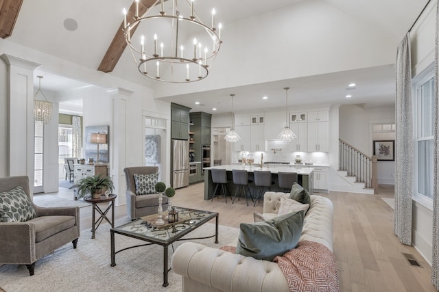 living room featuring beamed ceiling, high vaulted ceiling, light hardwood / wood-style floors, and ornate columns