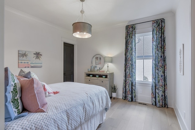 bedroom featuring crown molding and light hardwood / wood-style flooring