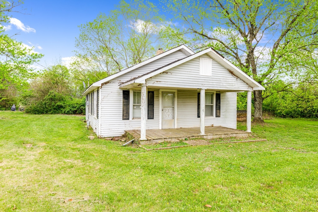 bungalow-style home with covered porch and a front yard