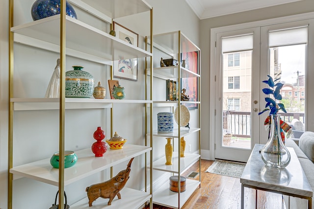 doorway to outside featuring ornamental molding and light hardwood / wood-style floors