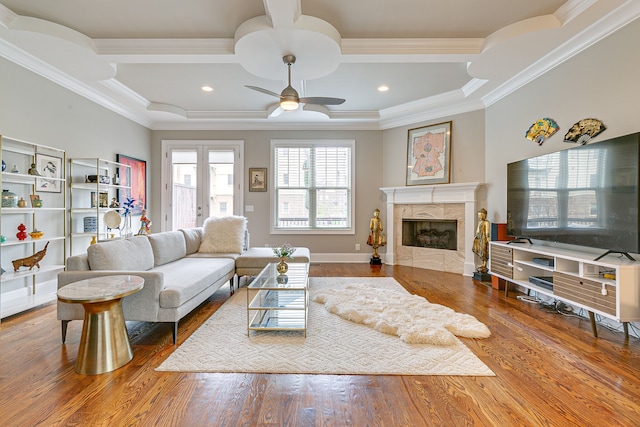 living room with wood-type flooring, ceiling fan, and a fireplace