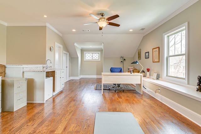 bedroom featuring crown molding, multiple windows, light hardwood / wood-style flooring, and sink