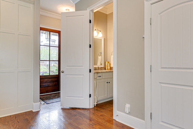 entryway featuring dark hardwood / wood-style flooring, sink, and ornamental molding