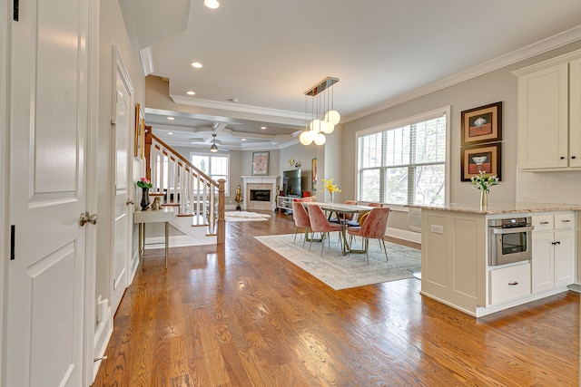 interior space with coffered ceiling, ceiling fan, beamed ceiling, light hardwood / wood-style flooring, and crown molding