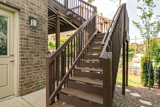 staircase featuring brick wall