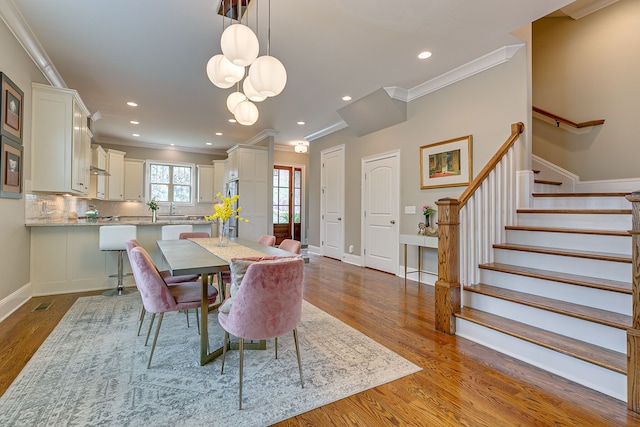 dining space featuring crown molding, dark hardwood / wood-style floors, and sink