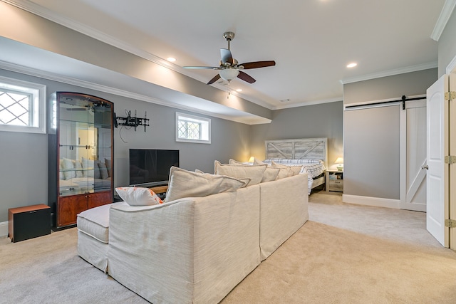 carpeted living room featuring a barn door, ornamental molding, ceiling fan, and a wealth of natural light