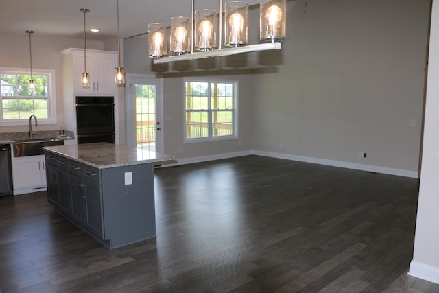 kitchen featuring sink, black double oven, white cabinets, and dark wood-type flooring