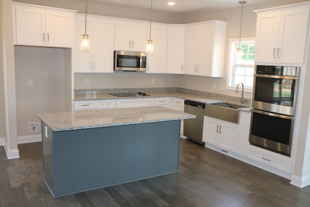 kitchen with decorative light fixtures, white cabinets, sink, appliances with stainless steel finishes, and dark wood-type flooring