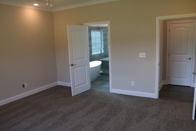 unfurnished bedroom with ornamental molding, connected bathroom, and dark carpet