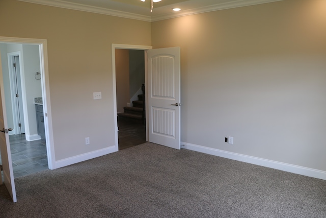 unfurnished bedroom featuring crown molding and carpet